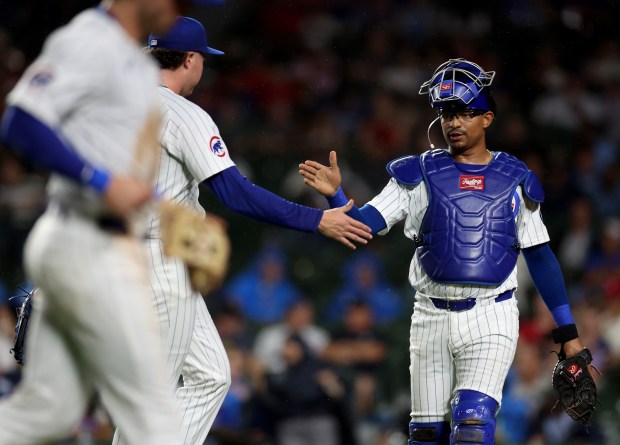 Chicago Cubs catcher Christian Bethancourt high-fives relief pitcher Nate Pearson after the duo shut down the St. Louis Cardinals in the 9th inning of a game at Wrigley Field in Chicago on Aug. 1, 2024. (Chris Sweda/Chicago Tribune)