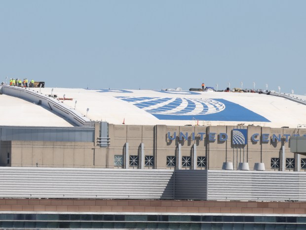 Workers on the roof of the United Center, Friday, Aug. 9, 2024, ahead of the upcoming Democratic National Convention. (Antonio Perez/Chicago Tribune)