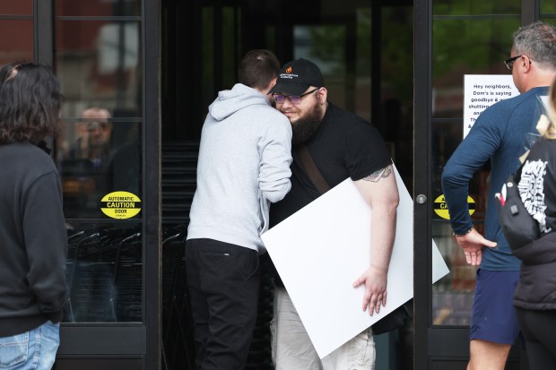 Former Dom's Kitchen & Market employees embrace outside the store on Halsted Street at Diversey Parkway in Chicago after the store was abruptly closed and employees were let go on April, 23, 2024. (Terrence Antonio James/Chicago Tribune)