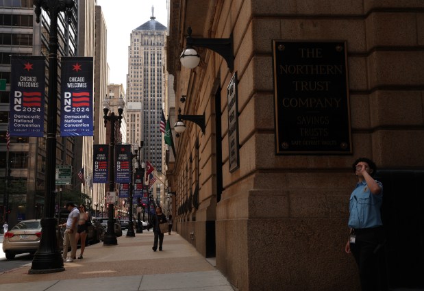 A security guard drinks water during his break along South LaSalle Street in Chicago on Aug. 22, 2024. The Loop was quiet during the Democratic National Convention. (Stacey Wescott/Chicago Tribune)