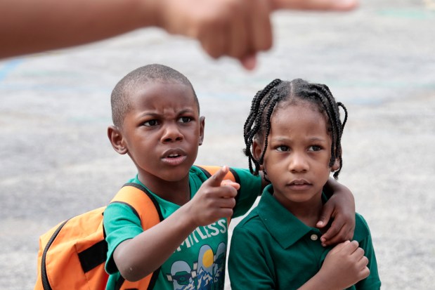 Two students are given directions on which way to enter on their first day back to school at Chalmers Elementary Specialty School on Monday, Aug. 26, 2024. (Antonio Perez/Chicago Tribune)