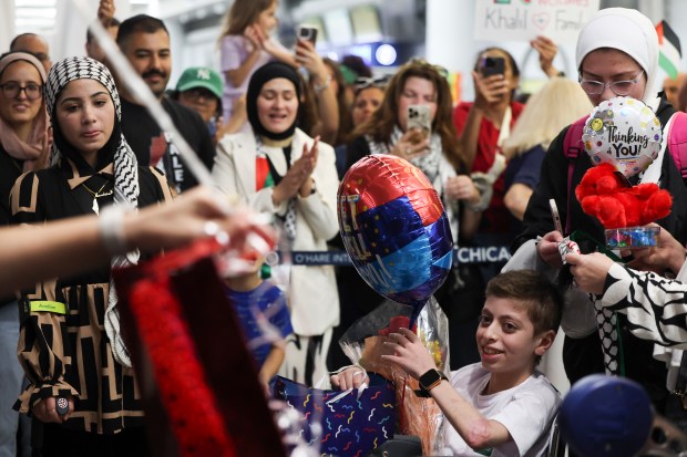 HEAL Palestine volunteers and community members welcome Khalil Abu Shaban, 13, and his family at O'Hare International Airport on Aug. 7, 2024. HEAL Palestine made arrangements to bring Khalil to America for medical treatment after he lost both of his legs in a bombing in Gaza. (Eileen T. Meslar/Chicago Tribune)