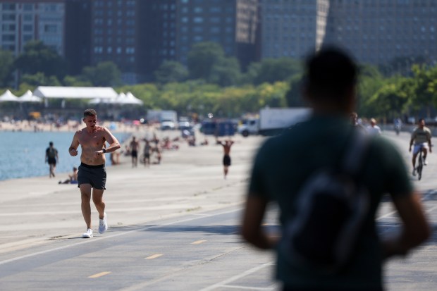 A jogger runs near North Avenue Beach on Monday, Aug. 26, 2024. (Eileen T. Meslar/Chicago Tribune)