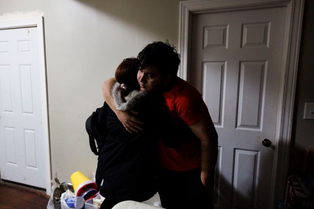 Esperanza Mendez hugs her son Fabián before she's taken to Stroger Hospital to have her lipoma surgically removed early on Jan. 29, 2024. Mendez said the lump on her neck had been growing for three years causing pain and discomfort throughout her whole body, especially her arms and legs. (Armando L. Sanchez/Chicago Tribune)