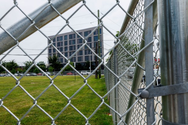 A fence surrounds a field next to the 12th District Chicago Police Station on Aug. 2, 2024 in Chicago. According to migrants several personal belongings were thrown away by officials when they were removed from the space in late June. (Armando L. Sanchez/Chicago Tribune)