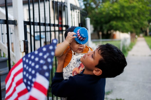 Pedro Mendez holds his 10-month-old nephew Derick Alexander Cubillan's outside their home during the Fourth of July holiday. (Armando L. Sanchez/Chicago Tribune)