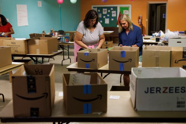 From left, volunteers Heather Oliver, 53, and Mylene Pollock, 64, make care packages for migrants in the basement of St John's Lutheran Church on Aug. 12, 2024, in Wilmette. The packages were built by Service and Learning Together volunteers in anticipation of migrant arrivals before the Democratic National Convention. (Armando L. Sanchez/Chicago Tribune)