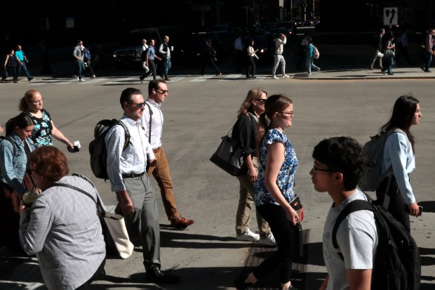 Pedestrians cross Wacker Drive at Adams Street during the morning rush in downtown Chicago, July 1, 2024. (Antonio Perez/Chicago Tribune)