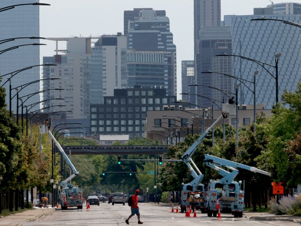 Crews from Streets and Sanitation paint light poles adjacent to the United Center on July 26, 2024, along Warren Boulevard and Wood Street, in preparation for the Democratic National Convention in Chicago. (Antonio Perez/Chicago Tribune)