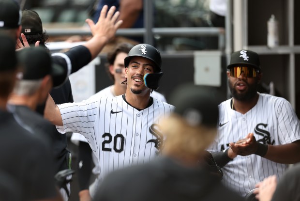 Chicago White Sox third baseman Miguel Vargas (20) is congratulated by his teammate in the dugout after scoring a run in the third inning of a game against the Texas Rangers at Guaranteed Rate Field in Chicago on Aug. 28, 2024. (Chris Sweda/Chicago Tribune)