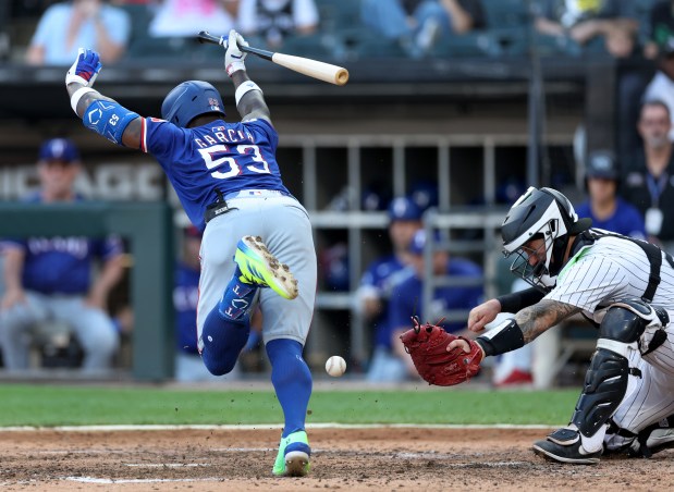 Texas Rangers batter Adolis García (53) jumps out of the way of a pitch as Chicago White Sox catcher Korey Lee (26) tries to catch the ball in the seventh inning of a game at Guaranteed Rate Field in Chicago on Aug. 28, 2024. (Chris Sweda/Chicago Tribune)