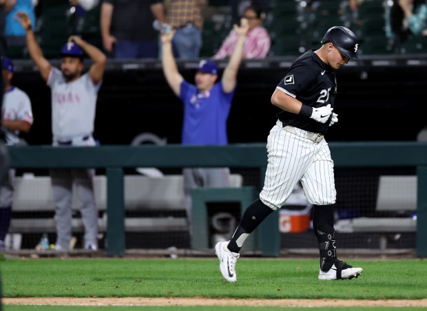 Chicago White Sox designated hitter Andrew Vaughn (25) runs back to the dugout as the Texas Rangers bench celebrates after a game-saving catch by outfielder Travis Jankowski in the ninth inning of a game at Guaranteed Rate Field in Chicago on Aug. 28, 2024. (Chris Sweda/Chicago Tribune)