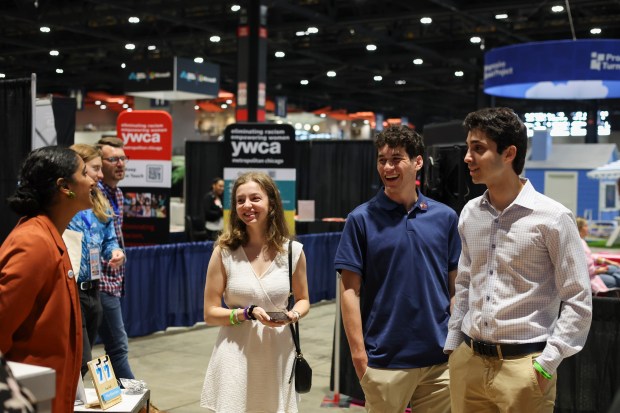 Emma Levine, from left, Drew Spiegel, and Sam Schwartz, check out the ActBlue booth at the DemPalooza at McCormick Place Convention Center on Aug. 19, 2024. (Eileen T. Meslar/Chicago Tribune)