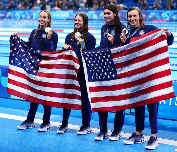 Silver Medalists Claire Weinstein, Paige Madden, Katie Ledecky and Erin Gemmell of Team United States pose with their national flag following the Swimming medal ceremony after the Women's 4x200m Freestyle Relay Final on day six of the Olympic Games Paris 2024 at Paris La Defense Arena on Aug. 01, 2024 in Nanterre, France. (Photo by Maddie Meyer/Getty Images)