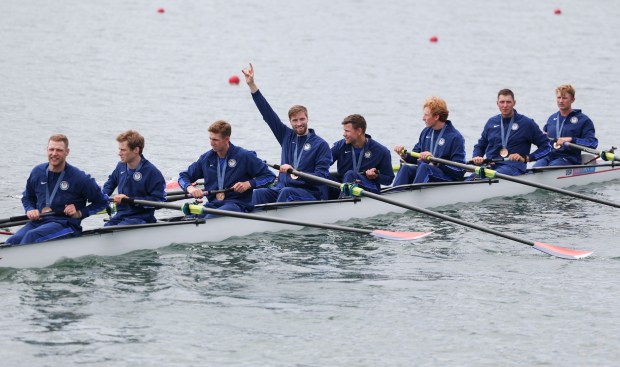 Peter Chatain, hand raised, and the USA men's eight boat row off with their bronze medals Saturday, Aug. 3, 2024, at Vaines-sur-Marne Nautical Stadium during the Paris Olympics. (Brian Cassella/Chicago Tribune)