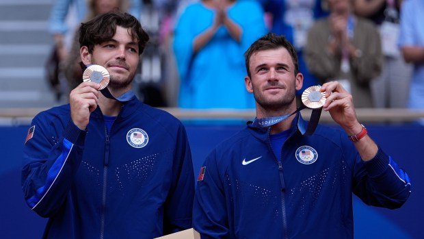 Tommy Paul of the United States pose with their bronze medal on the podium after the men's doubles final match at the Roland Garros stadium, at the 2024 Summer Olympics, Saturday, Aug. 3, 2024, in Paris, France. (AP Photo/Andy Wong)