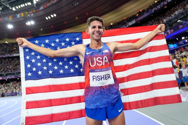 Grant Fisher, of the United States, poses after winning the bronze medal in the men's 10000 meters final at the 2024 Summer Olympics, Friday, Aug. 2, 2024, in Saint-Denis, France. (AP Photo/Matthias Schrader)