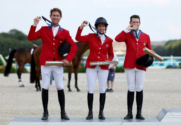 (L-R) Silver medalists Karl Cook, Laura Kraut and McLain Ward of Team United States pose for a photo during the medal ceremony for the Jumping Team Final on day seven of the Olympic Games Paris 2024 at Chateau de Versailles on Aug. 02, 2024 in Versailles, France. (Photo by Mike Hewitt/Getty Images)