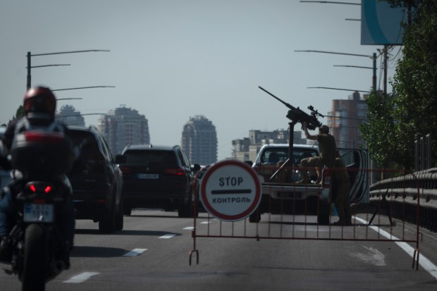 Ukrainian soldiers guard the sky with a machine-gun on a city road during one of Russian most massive missile and drone attack against Ukraine's energy objects in Kyiv, Ukraine, Monday, Aug. 26, 2024. (AP Photo/Efrem Lukatsky)