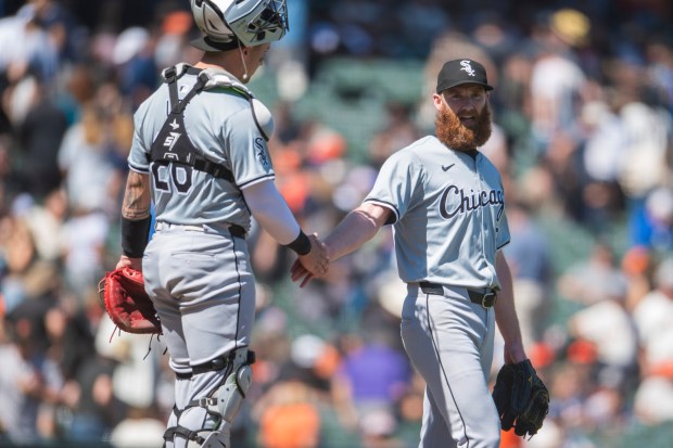 Chicago White Sox catcher Korey Lee (26) and pitcher John Brebbia (59) celebrate a win against the San Francisco Giants after a baseball game in San Francisco, Wednesday, Aug. 21, 2024. (AP Photo/Nic Coury)