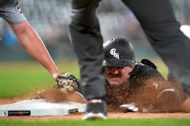 Chicago White Sox's Dominic Fletcher dives safely back to first after unsuccessfully trying to stretch his single into a double as Detroit Tigers first baseman Spencer Torkelson takes the throw from shortstop Trey Sweeney during the fourth inning of a baseball game Monday, Aug. 26, 2024, in Chicago. (AP Photo/Charles Rex Arbogast)