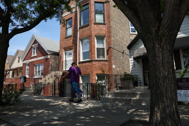 A person walks past a three-flat apartment on South Oakley Avenue in the Lower West Side neighborhood on July 22, 2024. Property owner Miguel Chacon has seen insurance rates rise for some of his buildings, including this one. (Eileen T. Meslar/Chicago Tribune)