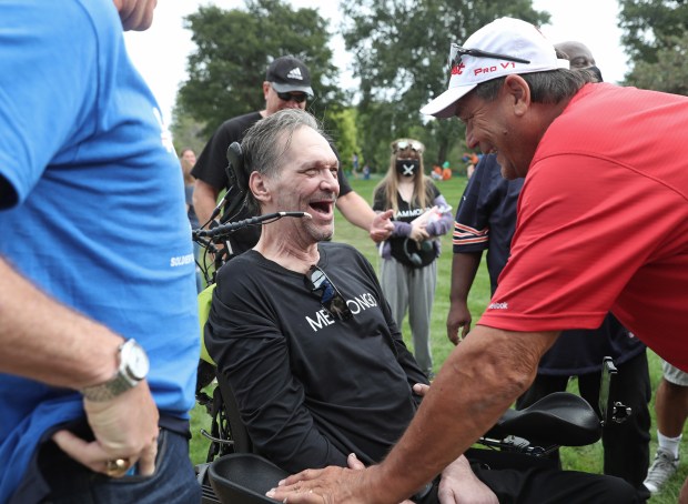 Former Chicago Bears players Steve McMichael, center, and Dan Hampton, right, laugh as they greet each other before the ALS Walk for Life at Soldier Field Saturday, Sept. 18, 2021, in Chicago. McMichael, who was diagnosed with ALS, received the Les Turner ALS Foundation Courage Award during the opening ceremony. (John J. Kim/Chicago Tribune)