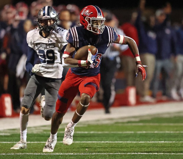 West Aurora's Terrence Smith (23) heads to the end zone in front of Oswego East's Andrew Karsten (29) during a Southwest Prairie Conference game in Aurora on Friday, Oct. 6, 2023.