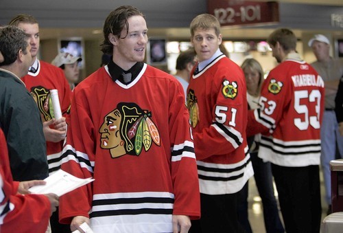 Duncan Keith, Vladimir Gusev and Nikolai Khabibulin greet fans before a preseason game at the United Center.