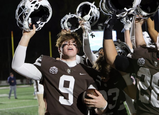 Mount Carmel quarterback Jack Elliott celebrates with his teammates after defeating Prospect in a Class 7A second-round playoff game in Chicago on Friday, Nov. 3, 2023.