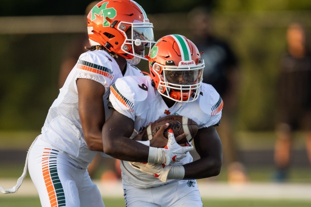 Morgan Park's Marcus Thaxton (4) hands off the ball to Terrance Gurley (9) against Richards during a nonconference game in Oak Lawn on Friday, Aug. 25, 2023.