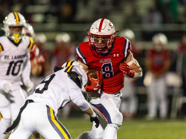 St. Rita's Nick Herman (8) tries to break free against St. Laurence during a CCL/ESCC crossover game in Chicago on Friday, Oct. 13, 2023.