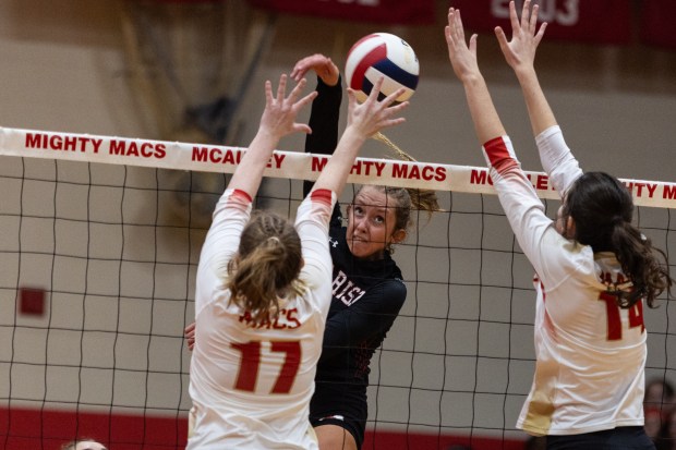 Marist's Bella Bullington tries to squeeze her swing past Mother McAuley's Keira Ohse (17) and Mary Claire Deacy (14) during a nonconference match in Chicago on Thursday, Sept. 21, 2023.