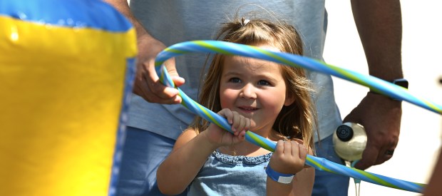 Myla Lindahl, 3, of Lake Villa is about to toss a hoop on the inflatable ring toss game in the Kids Zone Activities area of Gurnee Days on Aug. 10, 2024. (Karie Angell Luc/Lake County News-Sun)