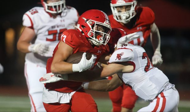 Naperville Central running back Aiden Clark (13) is tackled by Hinsdale Central's Hessen Alsheik (27) at Memorial Stadium in Naperville on Friday, Aug. 30, 2024. (Talia Sprague/for the Naperville Sun)