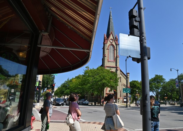 The tour group is at Lincoln Avenue and Brown Street during the Historic Downtown Skokie Walking Tour on Aug. 25, 2024 in downtown Skokie. (Karie Angell Luc/Pioneer Press)