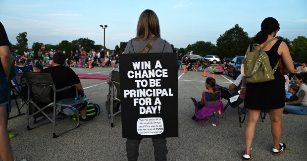 During the Isaac Fox "Back to School Bash" Aug. 23, 2024 in Lake Zurich, Lauren DeGiulio, vice president of the Isaac Fox PTO, wore a sign offering a chance to win the opportunity to be principal for a day. (Karie Angell Luc/Pioneer Press)