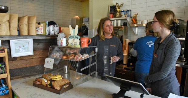 Center, Cathy Schiltz of Glenview, owner of the Glenview Grind, confers with employees at the register of the Glenview Grind (1837 Glenview Road) in Glenview on March 28, 2023. (Karie Angell Luc/Pioneer Press)