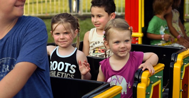 On a kiddie train ride, from left to right, in the second seat are Rori Ottenschot, 4, of upstate New York and Nelia Misterka, 2, of Clarendon Hills at the Village of Harwood Heights Annual Summer Festival and Carnival on Aug. 2, 2024 in Harwood Heights at Saint Monica and Rosalie Roman Catholic Parish (6750 W. Montrose Ave.) in Harwood Heights (Karie Angell Luc/Pioneer Press)