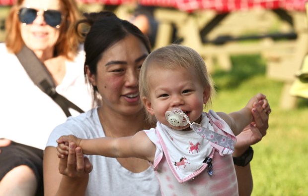 Dancing to the music of Kaleidoscope Eyes is tot Ruby Brant, 1, of Oriole Park with her mother Karna Brant at the Village of Harwood Heights Annual Summer Festival and Carnival on Aug. 2, 2024 in Harwood Heights at Saint Monica and Rosalie Roman Catholic Parish (6750 W. Montrose Ave.) in Harwood Heights (Karie Angell Luc/Pioneer Press)