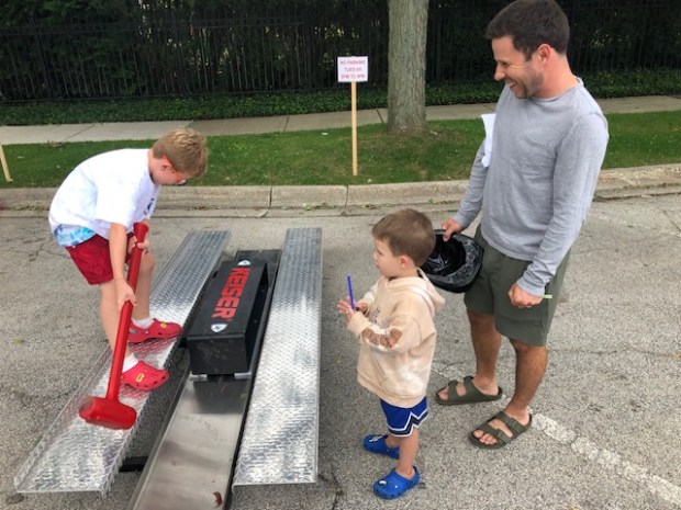 Morris Herscher, 7, tries to use a Keiser sledge as his brother, Casey, 4 and father, Eric, watch. (Daniel I. Dorfman)