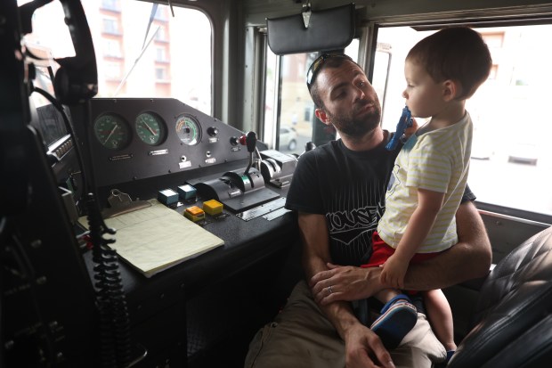 Matthew Jeadruczlk shows his son, George Jeadruczlk, age 2, the control panel of a Metra train engine during Railroad Day at the Franklin Park Festival in Franklin Park on Saturday, June 8, 2024. (Trent Sprague/for the Pioneer Press)