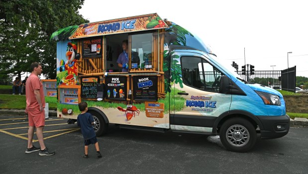 Sebastian Czubacki, 3, of Port Barrington and his father Kamil Czubacki are customers at the Kona Ice treat at the Food Truck Social event at Paulus Park in Lake Zurich on July 24, 2024. (Karie Angell Luc/Pioneer Press)