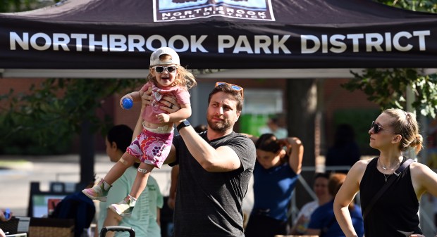 Just arriving to the event is parent Jeff Schoenfield of Northbrook, holding daughter Lila, 2, at Party on the Green on Aug. 17, 2024 at Village Green Park in Northbrook. (Karie Angell Luc/Pioneer Press)