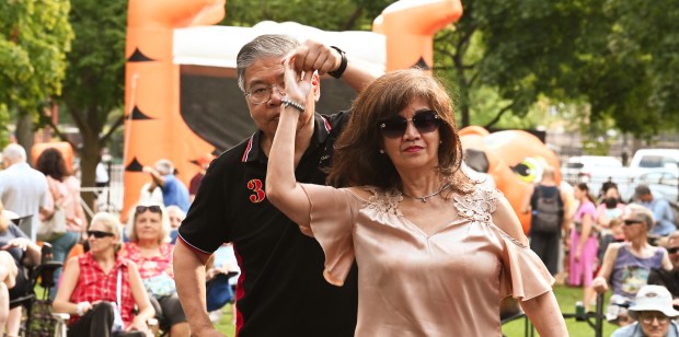 Dancing to the sounds of the group The Wayouts are Tom May of Northbrook and his wife May May at Party on the Green on Aug. 17, 2024 at Village Green Park in Northbrook. (Karie Angell Luc/Pioneer Press)