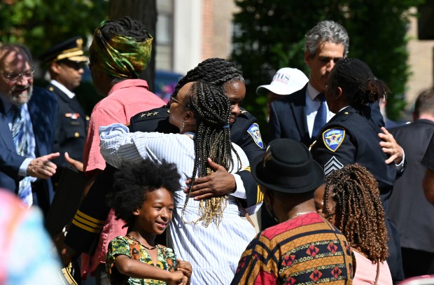 After the service, in striped shirt, Miah Logan of Evanston receives an embrace from Evanston Police Chief Schenita Stewart on Friday, Aug. 16, 2024 at the Evanston Police Department (1454 Elmwood Ave.) in Evanston at the memorial service for former Evanston Police Chief William H. Logan Jr. (Karie Angell Luc/Pioneer Press)