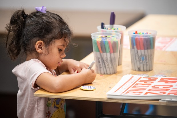 Camila, 3, makes her own protest button during a community conversation at the Hammond Public Library on the proposed BP CO2 pipeline on Wednesday, Aug. 21, 2024. (Kyle Telechan/for the Post-Tribune)