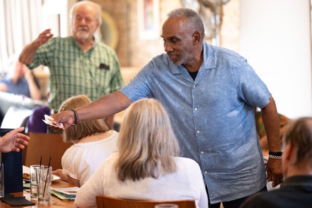 South Bend resident and Martin Luther King Senior Men's Club president Mike Jackson passes his business card to visitors during a public meeting to discuss the Chicago to Detroit Freedom Trail's path across Northwest Indiana in Gary on Wednesday, July 31, 2024. (Kyle Telechan/for the Post-Tribune)