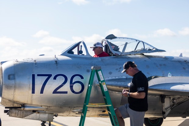 Mike Terfehr, cockpit, and Bill Culbertson of Fighter Jets Inc. go over some pre-flight checks on a MiG-17F before a rehearsal flight for the Gary Air Show, at the Gary Jet Center on Friday, Aug. 16, 2024, in Gary. (Vincent D. Johnson/for the Post-Tribune)