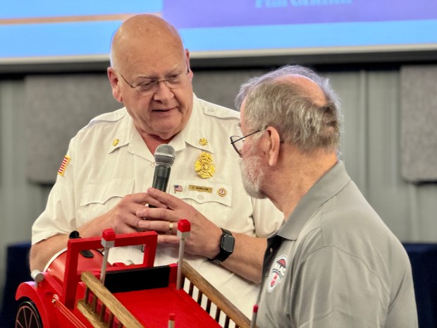 Former Task Force Tips President and CEO Stuart McMillan presents a firetruck mailbox to retired Valparaiso Fire Chief Phil Griffith, a longtime volunteer at the MAAC public safety training facility in Valparaiso, during a program on Thursday, Aug. 22, 2024. (Doug Ross/for Post-Tribune)